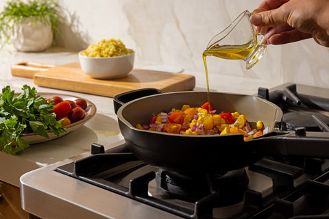 Cooking corn, cherry tomatoes and red onion in a skillet