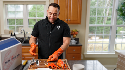 Julian demonstrating how to crack a cooked lobster in the kitchen