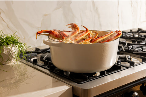 Snow crab clusters steaming in a pot on the stovetop